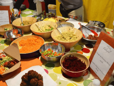 Variety of colorful dishes and fresh ingredients at the Upmarket Brick Lane Food Hall, reflecting the culinary diversity of the place.