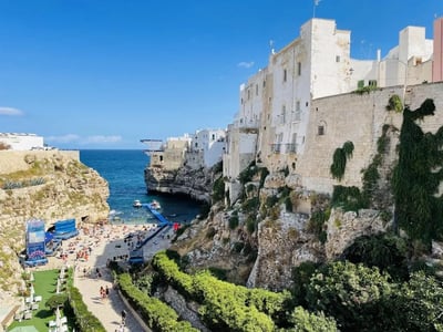 Picturesque Lama Monachile beach, surrounded by white cliffs and historic buildings, washed by turquoise waters.