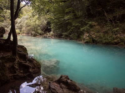 Peaceful turquoise waters lined with trees in Zudaire, creating an ideal natural setting for relaxation and contemplation.