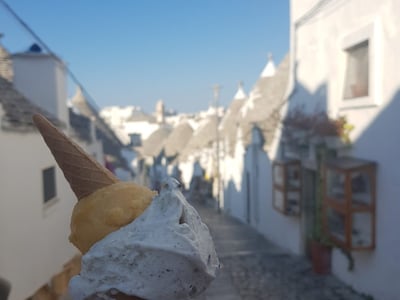 Cornet de glace avec boule citron et vanille, rue pittoresque de Mille Voglie, idéal pour une journée ensoleillée.