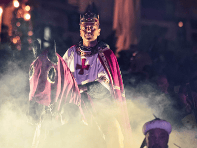 Knight in medieval costume at the Palio d'Oria, surrounded by mist and spectators amazed by this historical event.