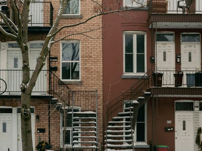 Brick house façades in Rosemont - La Petite-Patrie, with outdoor stairs and bare trees in winter.