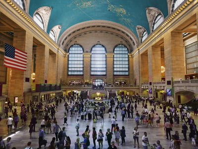 Animated interior of Grand Central, with travelers under a starry blue ceiling, capturing the vibrant essence of New York.