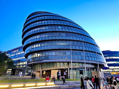 The modern silhouette of the Old Town Hall of London, surrounded by visitors admiring the contemporary architecture.