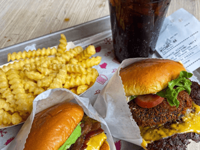 Deux hamburgers savoureux avec frites croustillantes et un soda, parfaits pour une pause gourmande au Shake Shack de Broadway.