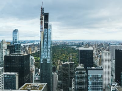 Aerial view of Central Park surrounded by skyscrapers in Manhattan, illustrating the contrast between nature and urbanism.