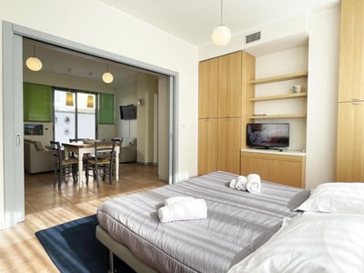 Chambre moderne à Euphorbia Residence, équipée d'un lit confortable, d'une télévision et d'une vue sur la salle à manger.
