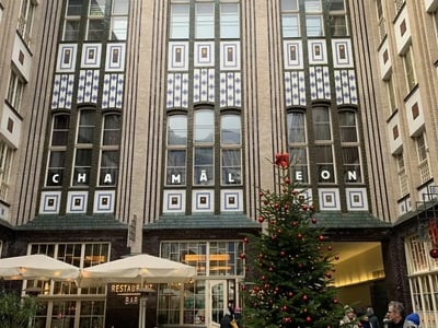 Entrance to Hackesche Höfe with festive decorations and a Christmas tree in front of the Chamaeleon restaurant.