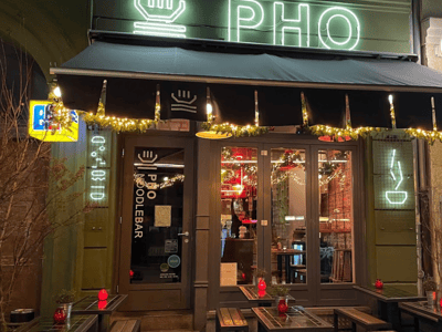 Fassade du PHO - Noodlebar illuminée, attirant les clients avec une ambiance chaleureuse et accueillante.