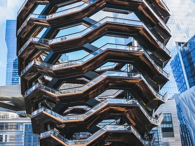Unique architectural structure of The Vessel in New York, with decorative staircases and a blue sky in the background.