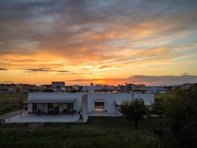 Coucher de soleil spectaculaire sur Casina Pompiliano, illuminant le paysage rural et créant une atmosphère paisible.
