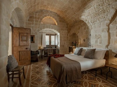 Chambre confortable à Locanda di San Martino, avec voûtes en pierre et décor apaisant, idéale pour un séjour relaxant.