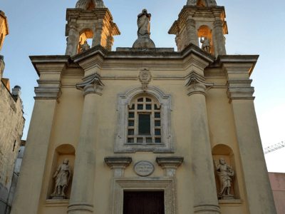 Facade of the Diocesan Museum with detailed statues and columns at dusk, highlighting its historical architecture.