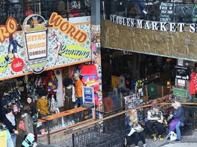 Colorful shop displays at Camden Market, with customers exploring eclectic fashion and lively stalls.