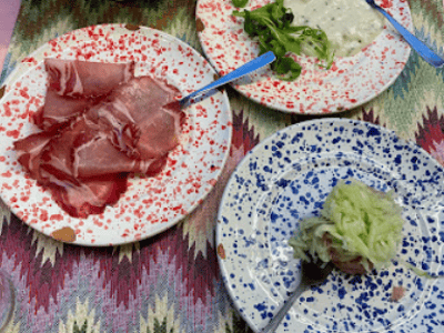 Italian charcuterie with prosciutto and condiments, enjoyed in a warm setting at Vino Fritti e Cucina.
