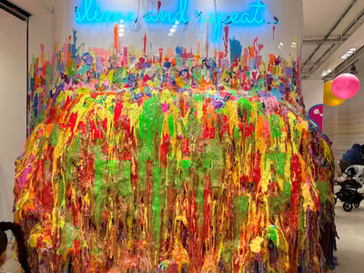 Mur coloré de slime au Sloomoo Institute, illustrant la créativité ludique et interactive de l'expérience.