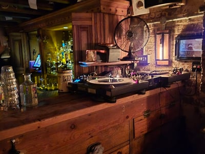 Vintage bar with a turntable and a warm atmosphere, ideal for an event at the Discount Suit Company.