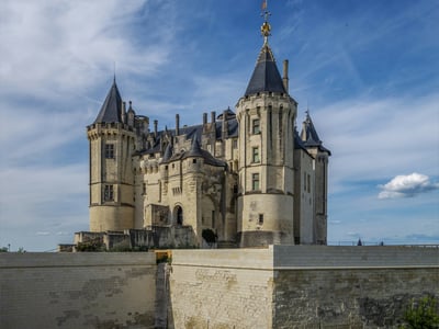 Saumur Castle, emblem of medieval architecture, with its distinctive towers under a clear blue sky.