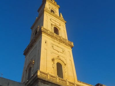 Tour majestueuse de la Torre dell'Orologio illuminée au coucher du soleil, située à Piazza Duomo, Lecce.