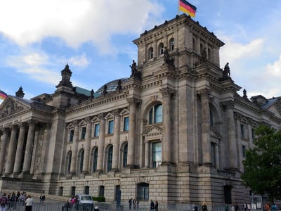 Imposing façade of the Reichstag in Berlin, emblem of German architecture with the flag flying at the top.
