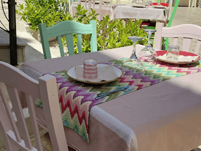Colorful tables arranged in a welcoming courtyard at Vino Fritti e Cucina, ready for a friendly outdoor meal.