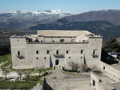 Vue aérienne du Château impérial, bâtisse historique surplombant les montagnes enneigées, symbole de l'architecture médiévale.