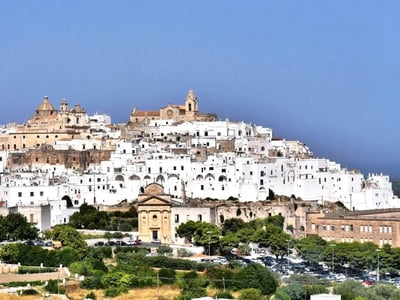 The city of Ostuni, nicknamed the "White City," with its white houses perched on a sunny hill.