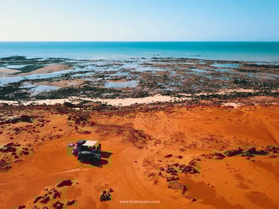 Desert landscape at James Prices Point, with a blue sea and an all-terrain vehicle on a reddish ground.