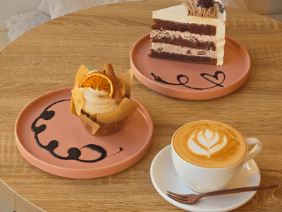 Two delicious desserts plated, accompanied by a creamy coffee at Café de Luna.