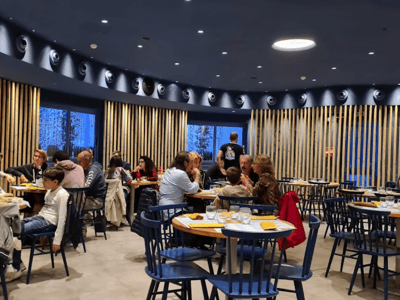 Intérieur du restaurant 400 Gradi, avec des clients profitant d'un repas convivial autour de tables en bois et d'une déco moderne.