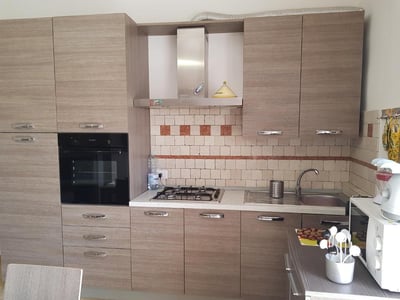 Cuisine moderne et fonctionnelle de La Casa di Nico, avec meuble en bois et plan de travail en marbre.