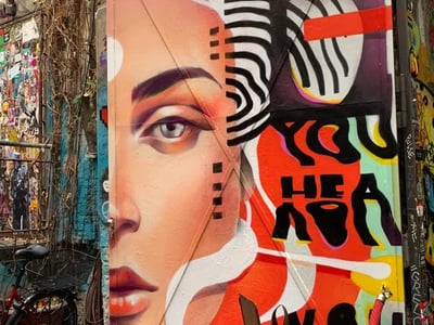 Colorful mural depicting a female face, located at Haus Schwarzenberg, celebrating urban art and creativity.