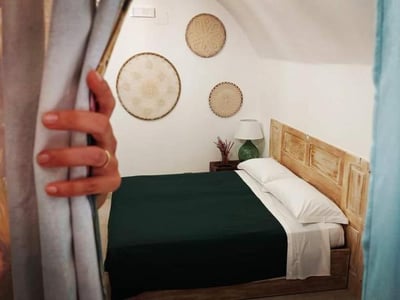 Comfortable room at Japp'ca, with walls decorated with baskets and an elegant bed, inviting relaxation.