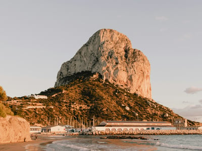 Majestic Ifach Rock in Calpe, overlooking a beautiful beach at sunset. Ideal for nature and landscape lovers.