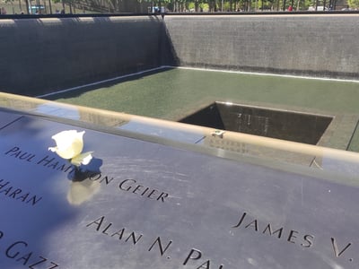 Fleur blanche posée sur le monument commémoratif des victimes au World Trade Center, symbole de mémoire et de paix.