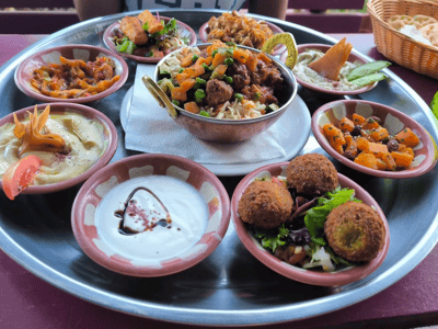 Variété de plats traditionnels servis dans un plateau à Baraka, incluant falafels, légumes, riz et sauces.
