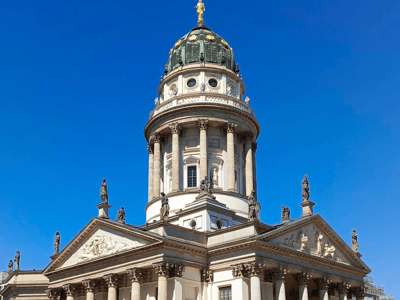 Vue du dôme doré du Französischer Dom, un symbole architectural majeur de Berlin, dans un ciel bleu éclatant.