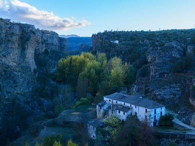 Vue panoramique des ruines blanches entourées de végétation, nichées dans les gorges d'Alhama de Granada.