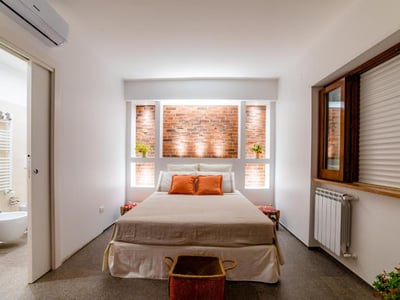 Chambre spacieuse et lumineuse au B&B Villa Maria Pia, décorée avec des tons chaleureux et des briques apparentes.