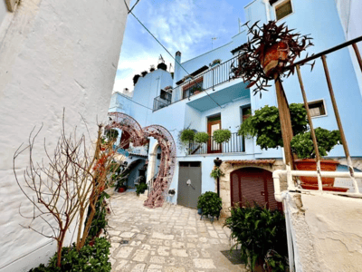 Rue pittoresque à Casamassima, ornée de plantes et d'une arche en fer, évoquant le charme méditerranéen.