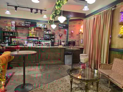 Interior of the iconic FRIENDS café, with a rustic counter decorated for the holidays, creating a nostalgic atmosphere.