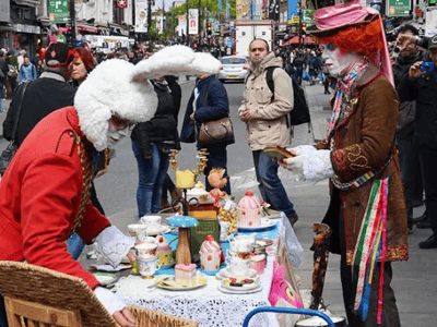 Colorful street musicians and fantastical characters in a festive atmosphere at Camden Market, London.