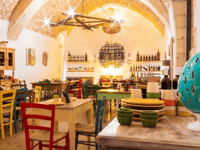 Intérieur chaleureux de Pizzeria Terra Rossa avec des tables en bois colorées et une ambiance conviviale.