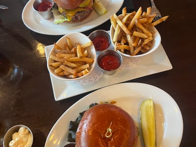 Délicieux hamburgers avec frites croustillantes et sauces, servis au Five Napkin Burger, restaurant réputé à New York.
