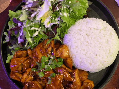 Stir-fried chicken in sweet sauce, served with white rice and a fresh salad at Mista Oh. A delight not to be missed!