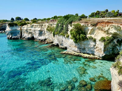 White cliffs overlooking the crystal-clear waters of Melendugno, in a beautiful and sunny natural setting.