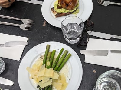 Tasty dish of green beans accompanied by cheese, with a slice of bread and a dish at Rochelle Canteen, London.