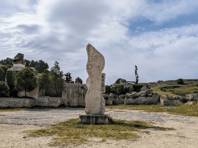 Sculpture monumentale au Parco Scultura La Palomba, se dressant parmi la verdure sous un ciel nuageux.