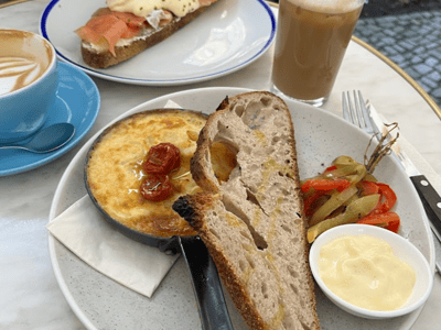 Delicious lunch at Father Carpenter: eggs, artisan bread, and fresh toppings, accompanied by iced coffee.