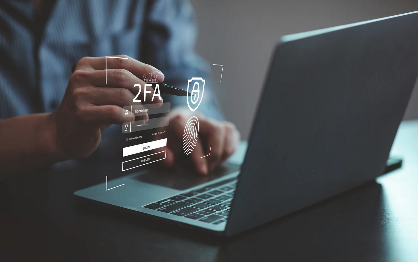 Two-Factor Authorisation Person using a laptop with virtual graphics showing two-factor authentication, password entry, fingerprint scan, and security icons.